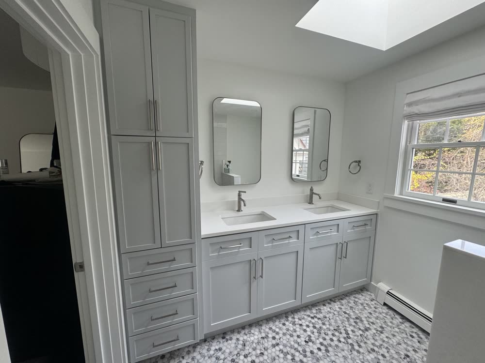 Renovated bathroom with double vanity and linen tower