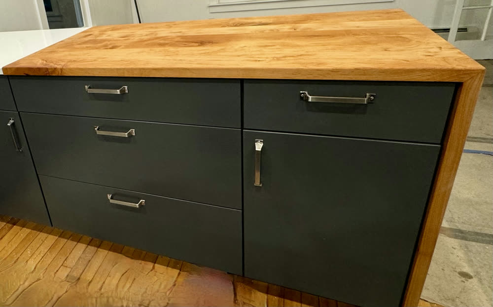 Dark lower cabinets with a butcher-block top